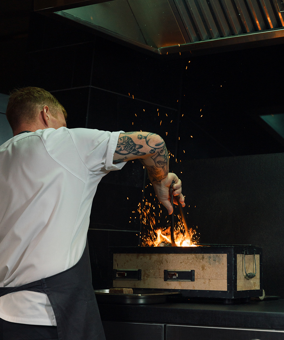 Aulis Phuket's head chef cooking over a fire