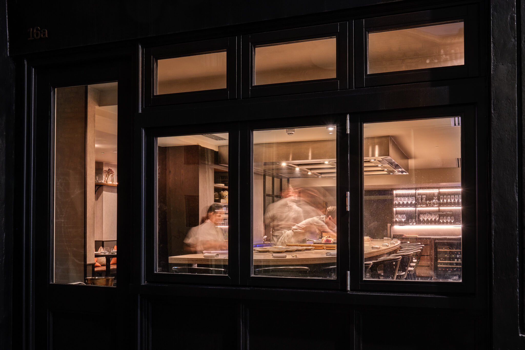 A view of Ausli's London's chef's table through a window from the street