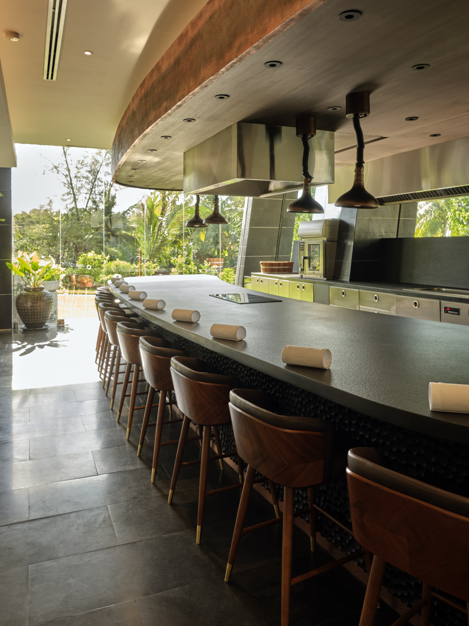 The table set up in the restaurant at Aulis Phuket with the garden in the background
